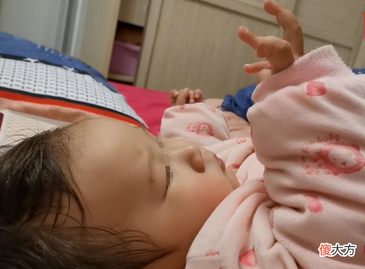 小婴儿专心“掰手指”，表情有些淡淡的忧伤，是在算挨训几次吗？